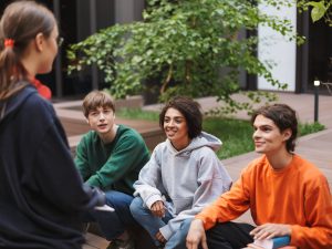 group-of-smiling-students-sitting-and-happily-spen-2024-10-18-17-36-00-utc