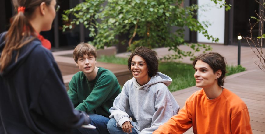 group-of-smiling-students-sitting-and-happily-spen-2024-10-18-17-36-00-utc